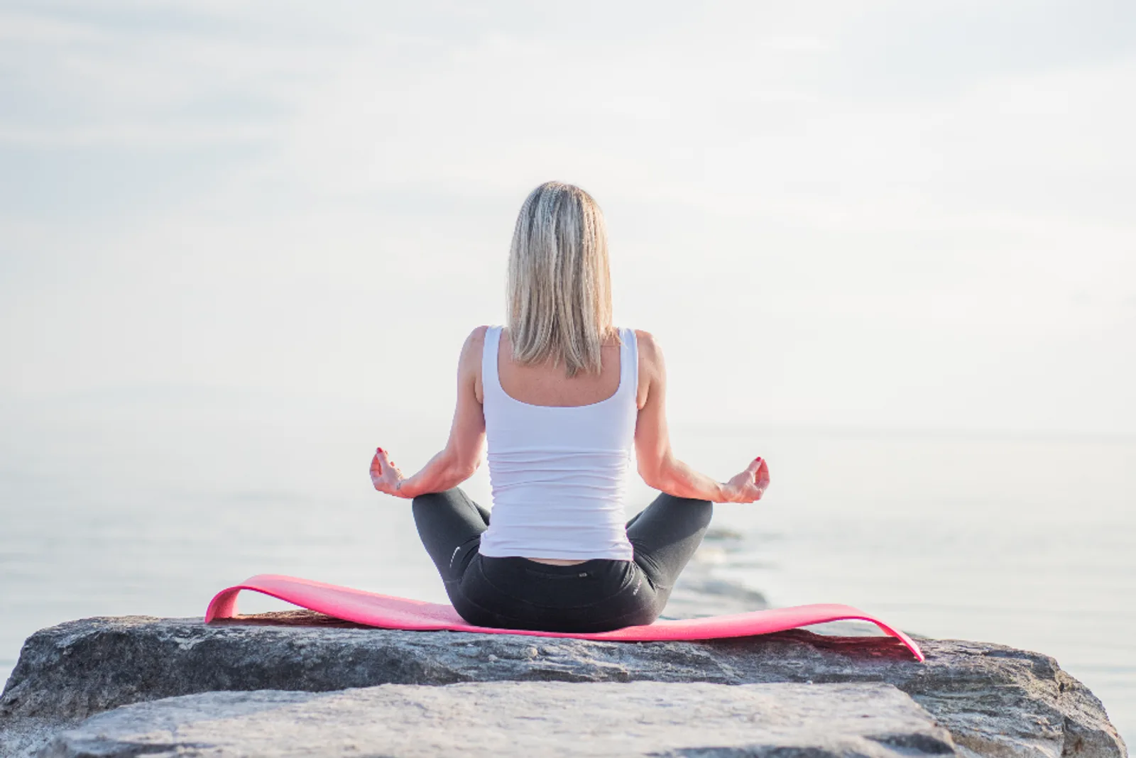 A woman meditating by the sea